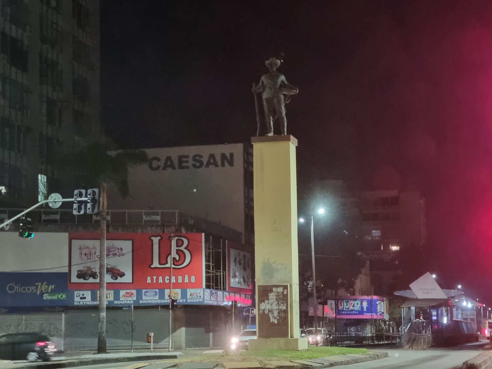 Esquina da Avenida Anhanguera com Avenida Goiás à noite, no Centro de Goiânia, com comércio e movimento