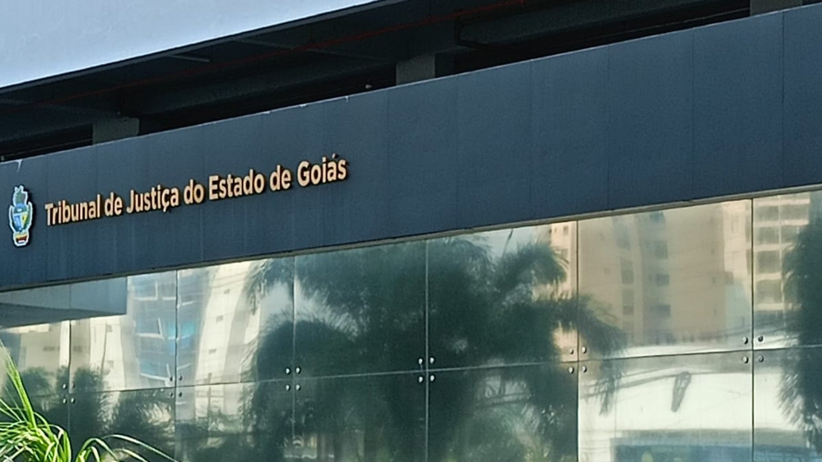 Fachada do Tribunal de Justiça do Estado de Goiás, com o nome da instituição em letras douradas sobre painel azul